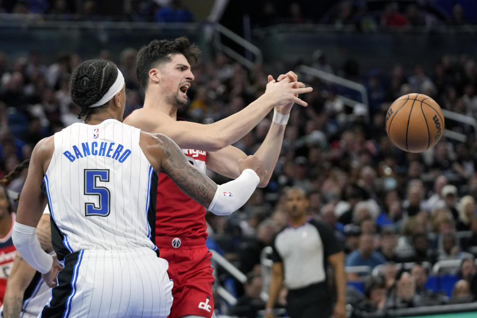 Washington Wizards' Deni Avdija, right, loses the ball as he tries to pass against Orlando Magic's Paolo Banchero (5) during the second half of an NBA basketball game, Tuesday, March 21, 2023, in Orlando, Fla. (AP Photo/John Raoux)