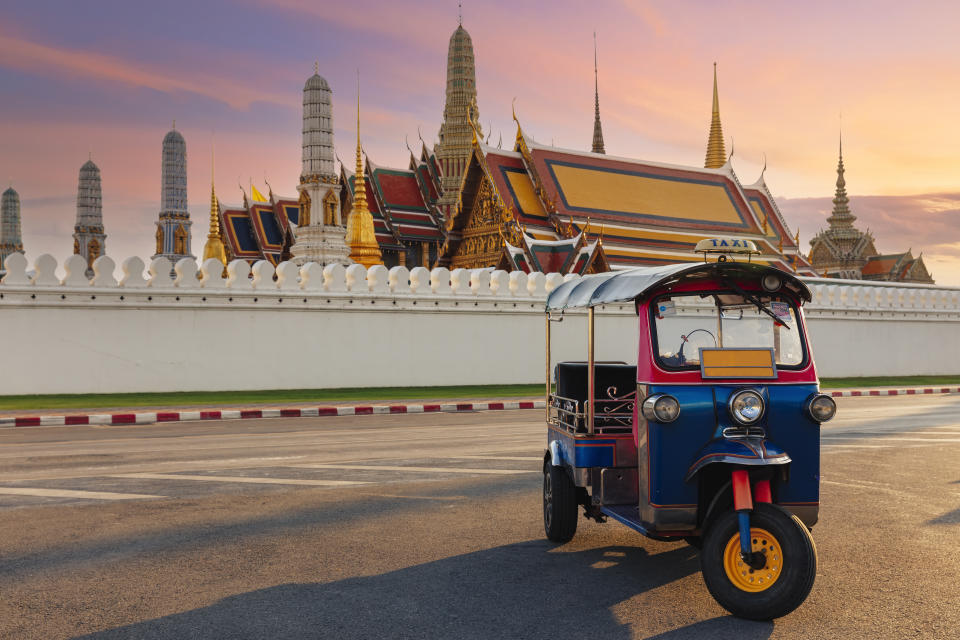 A photo of a Tuk Tuk Taxi or Three-Wheel Vehicle with Wat Phra Kaeo background.