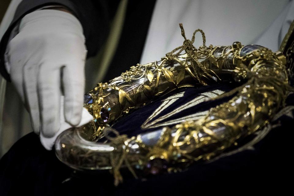 In this file photo taken on April 14, 2017 shows a priest wiping the Crown of Thorns, a relic of the passion of Christ- at the Notre-Dame Cathedral in Paris.