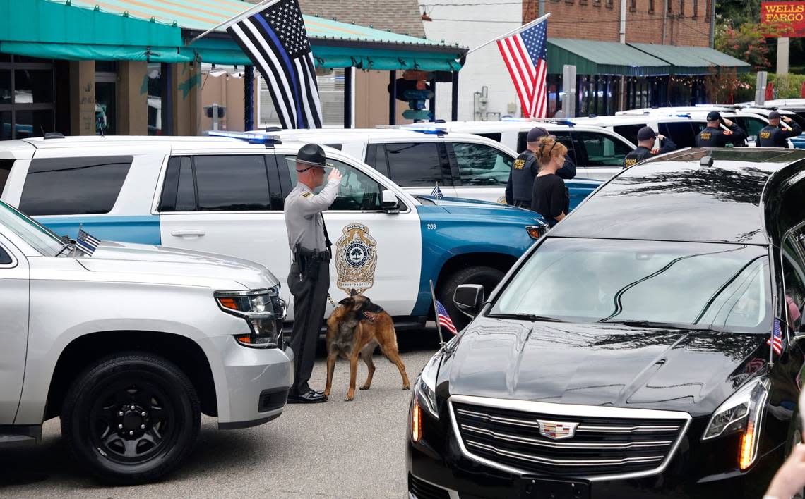 K9 officers salute as the procession for slain Wake County Sheriffs Deputy Ned Byrd passes them on Glenwood Avenue in the Five Points neighborhood in Raleigh, N.C., Friday, August 19, 2022.