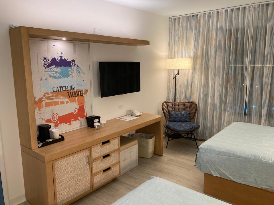 light wooden desk and armoire and TV on wall in dockside standard room