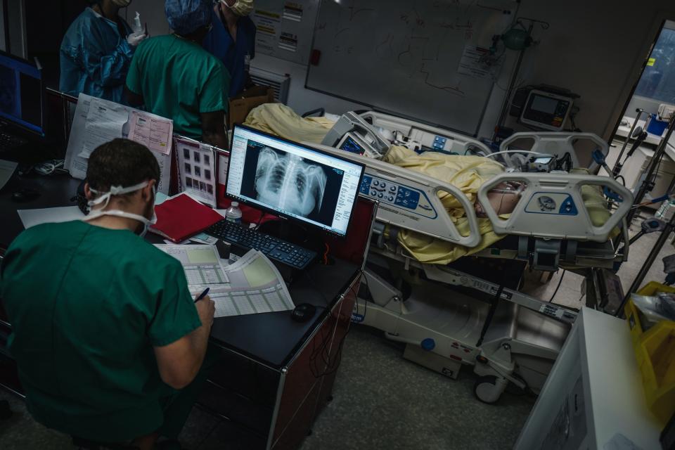 Varios miembros del personal sanitario del Hospital Lariboisiére de París trasladan a un paciente con coronavirus a la unidad de cuidados intensivos. (Foto: Lucas Barioulet / AFP / Getty Images).