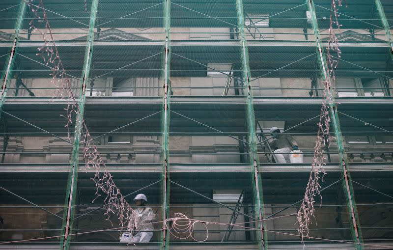 Workers are seen on a scaffolding of a building in Rome