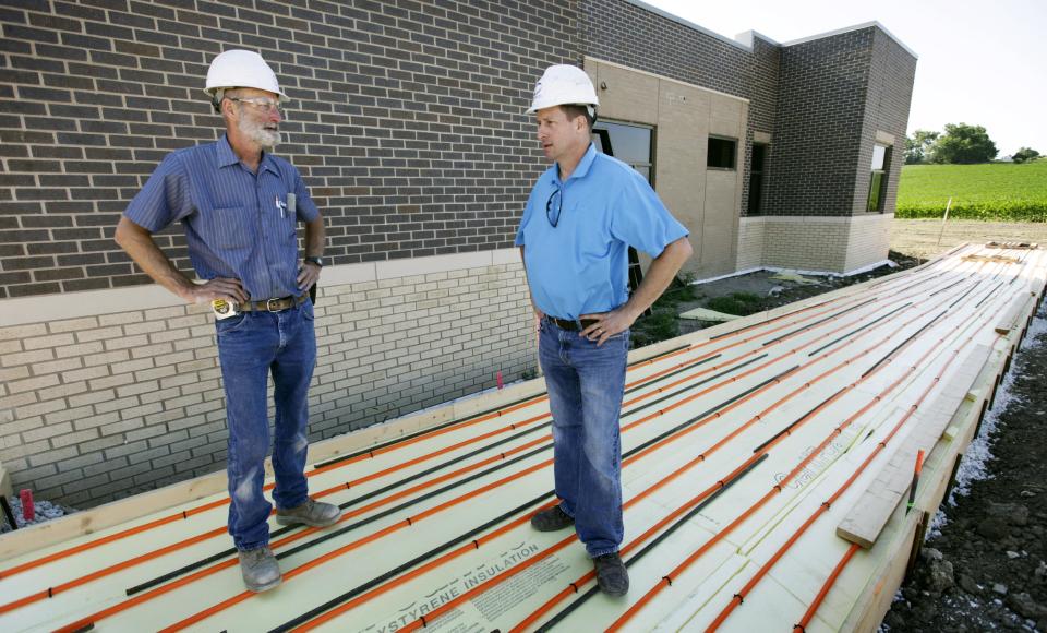 In this Tuesday, June 19, 2012 photo, electrical contractor Howie Drees talks with foreman Don Irlbeck, left, on a job site in Carroll, Iowa. "I would say Obama and his staff stepped up and made some tough decisions and put some money out there and kept things moving," says Drees, who says up half the projects he's worked on in recent years involved federal funds. "I was happy to see someone actually try to stimulate the economy with low interest rates, instead of waiting until more damage was done." (AP Photo/Charlie Neibergall)