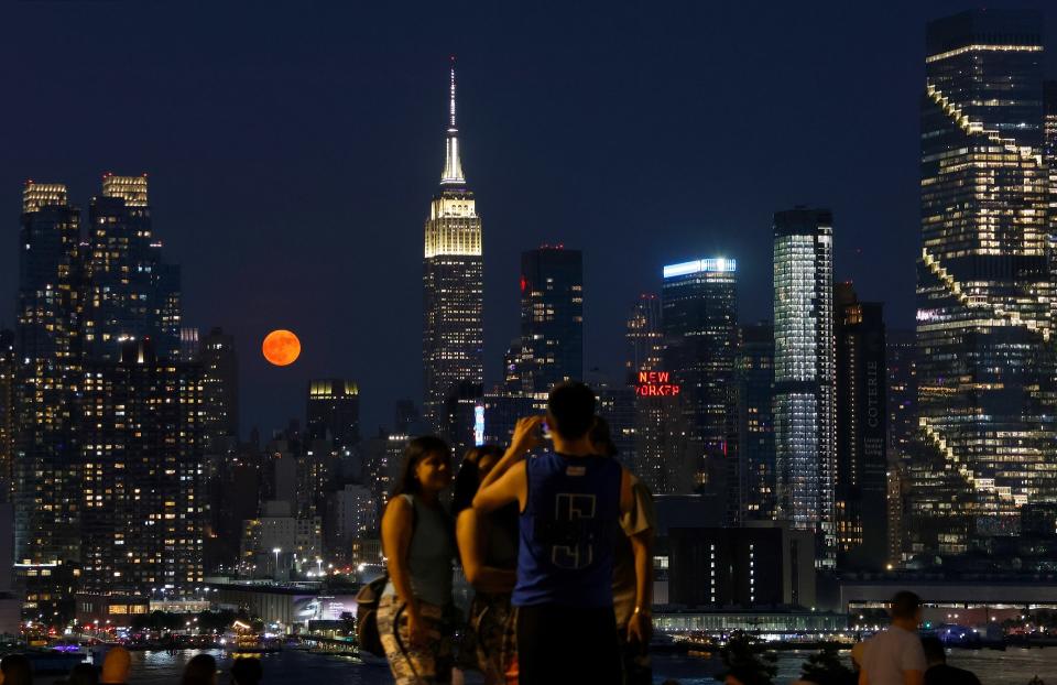 Der volle Erdbeermond geht am 21. Juni 2024 hinter dem Empire State Building in New York auf, von Weehawken, New Jersey aus gesehen.