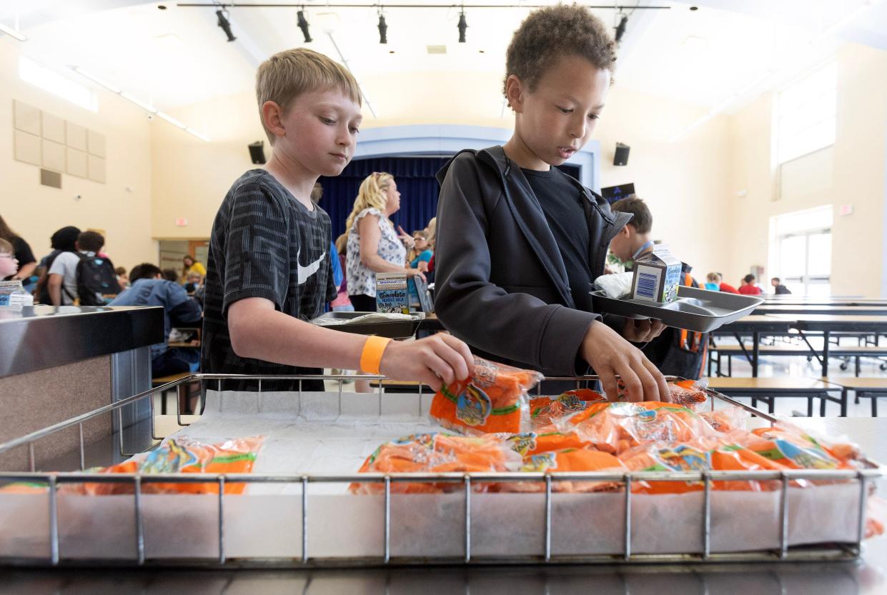 Jaden Carpenter, 11, left, and Joshua Sexton ,10, pick out carrots at Alliance Elementary School during the Alliance City School District's summer food program. Alliance is offering free breakfast and lunch at three separate sites this summer through Ohio's Summer Food Service Program.