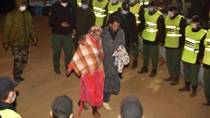 Rescue teams join hands as the parents of five-year-old Rayan leave the scene where their son&#39;s body was taken by ambulance