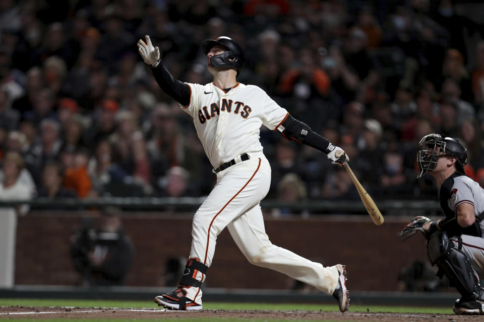 San Francisco Giants' Buster Posey hits a sacrifice fly against the Arizona Diamondbacks during the third inning of a baseball game in San Francisco, Thursday, Sept. 30, 2021. (AP Photo/Jed Jacobsohn)