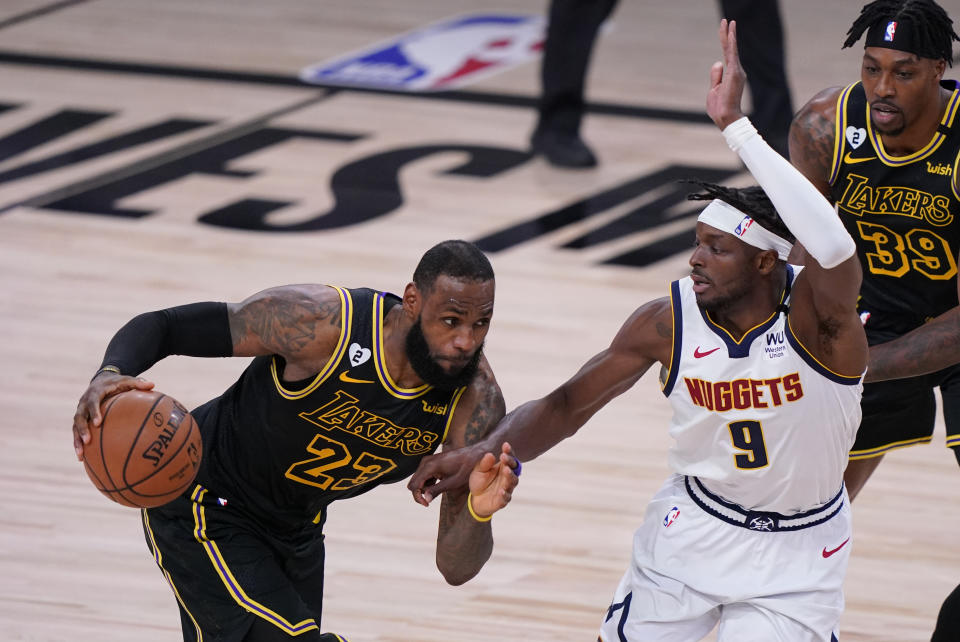 Los Angeles Lakers' LeBron James (23) drives past Denver Nuggets' Jerami Grant (9) during the second half of an NBA conference final playoff basketball game Sunday, Sept. 20, 2020, in Lake Buena Vista, Fla. (AP Photo/Mark J. Terrill)