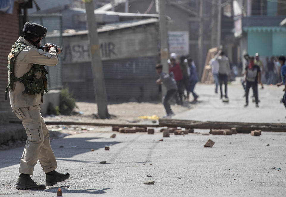 An Indian paramilitary soldier aims his pellet gun on Kashmiri protesters marching on the streets in solidarity with rebels engaged in a gunbattle with soldiers, in Srinagar, Indian controlled Kashmir, Thursday, Sept. 17, 2020. The gunfight erupted shortly after scores of counterinsurgency police and soldiers launched an operation based on a tip about the presence of militants in a Srinagar neighborhood, Pankaj Singh, an Indian paramilitary spokesman, said. (AP Photo/Mukhtar Khan)