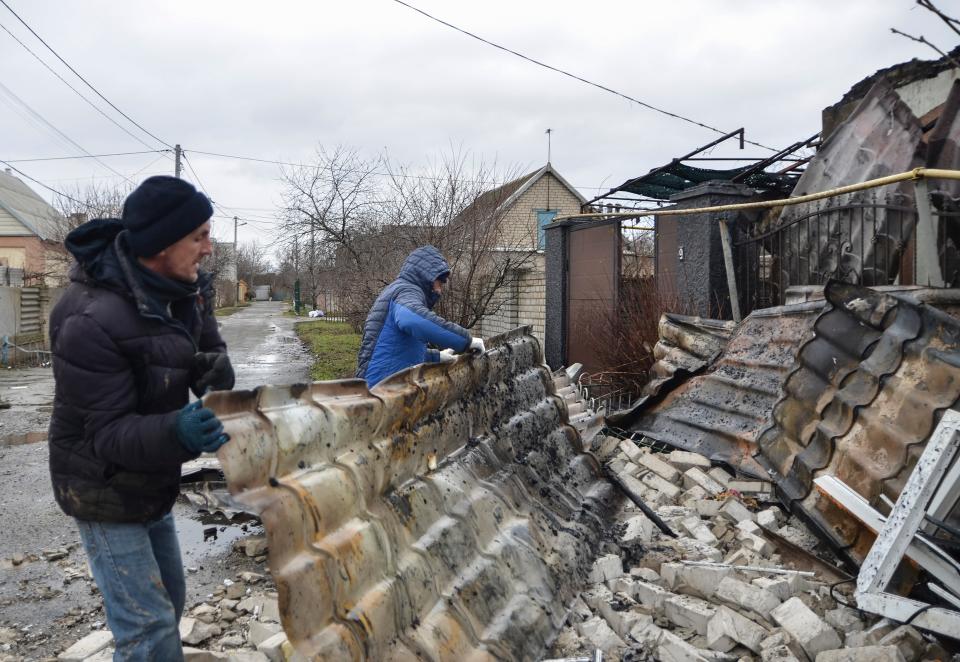 Locals clean debris after shelling in Kherson, Ukraine, 6 January 2022 (EPA)