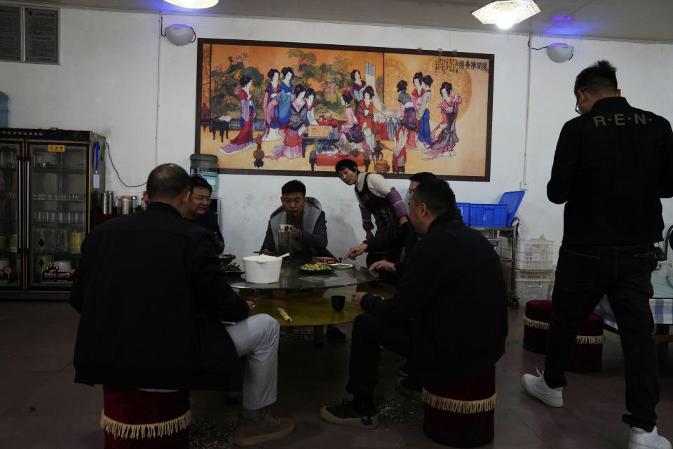 People eat in a restaurant outside of Kunming in southern China's Yunnan province on Monday, Nov. 30, 2020. More than a year since the first known person was infected with the coronavirus, an Associated Press investigation has found the Chinese government is strictly controlling all research into its origins, clamping down on some while actively promoting fringe theories that it could have come from outside China. (AP Photo/Ng Han Guan)