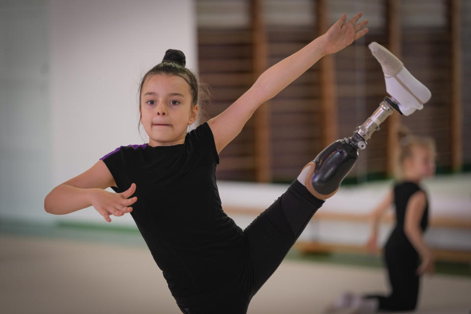 Oleksandra Paskal, an 8-year-old girl with a prosthetic leg, practices rhythmic gymnastics with other girls in Chornomorsk, Odesa region, Ukraine, Thursday, May 16, 2024. Two years after her injury, the girl who once aimed to compete at the Olympic Games now dreams of the Paralympics. (AP Photo/Efrem Lukatsky)