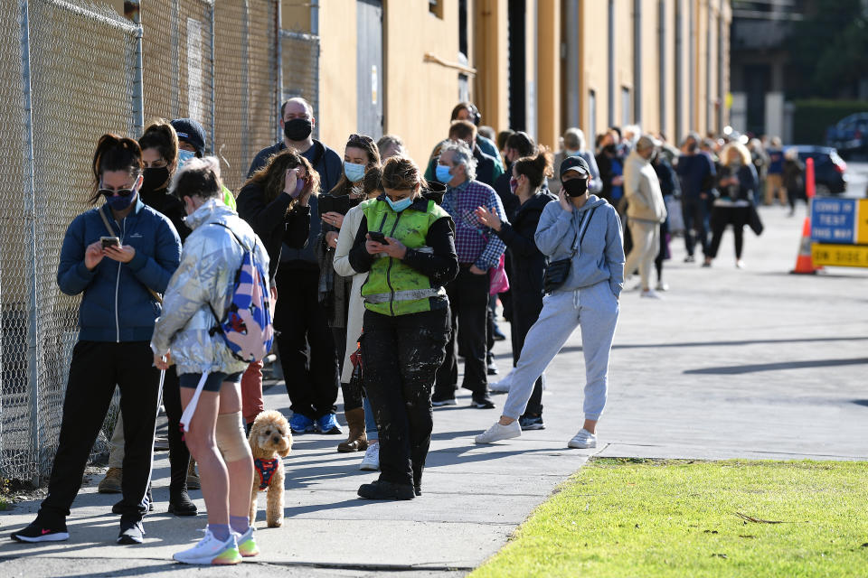 People are seen waiting in line outside of the Palais Theatre at a pop-up Covid19 testing facility in St Kilda. Source: AAP