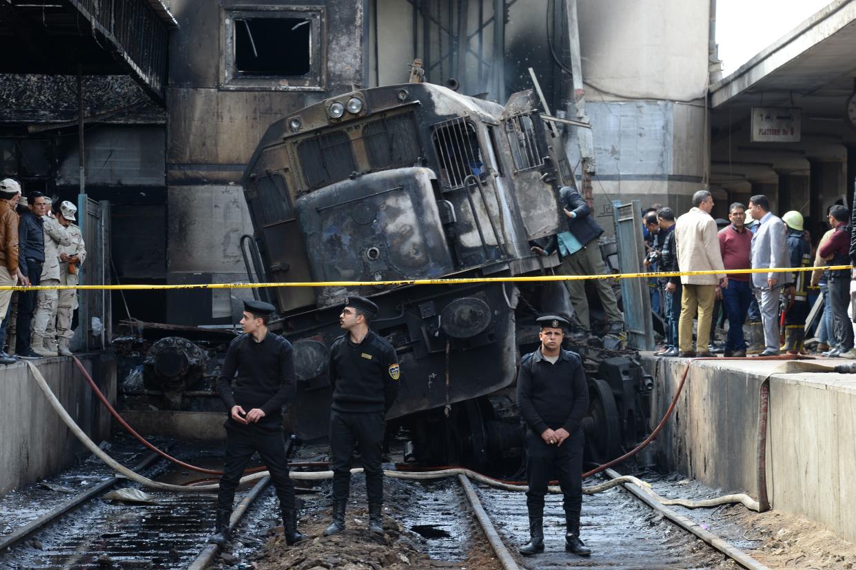 Fire fighters and onlookers gather at the scene of the fiery train crash at the Egyptian capital Cairo’s main railway station. (MOHAMED EL-SHAHED/AFP/Getty Images)