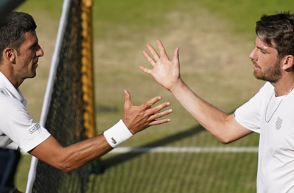 Serbia's Novak Djokovic, left, greets Britain's Cameron Norrie at the net after beating him in a men's singles semifinal on day twelve of the Wimbledon tennis championships in London, Friday, July 8, 2022. (AP Photo/Gerald Herbert)