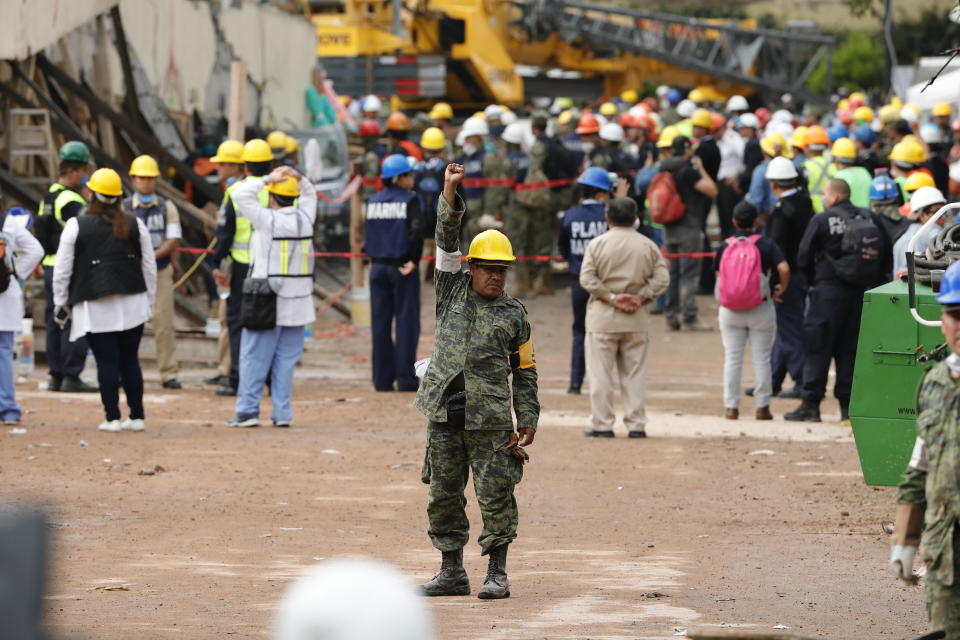 <p>A member of the Mexican Army raises his hand asking for absolute silence as rescue services and volunteers search for victims under the debris of the school that collapsed in Mexico City, Mexico, Sept. 21, 2017. (Photo: Jose Mendez/EPA-EFE/REX/Shutterstock) </p>