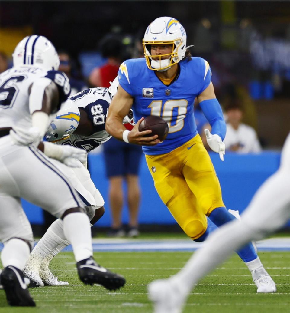 Chargers Justin Herbert looks to run from the pocket against the Cowboys.