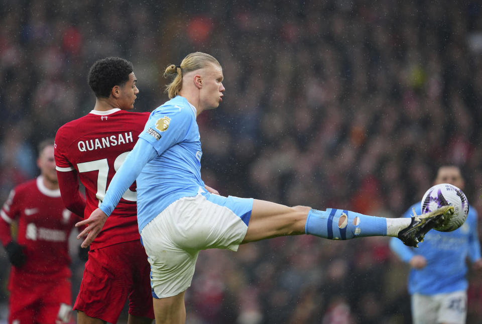 Manchester City's Erling Haaland, foreground, fights for the ball with Liverpool's Jarell Quansah during the English Premier League soccer match between Liverpool and Manchester City, at Anfield stadium in Liverpool, England, Sunday, March 10, 2024. (AP Photo/Jon Super)