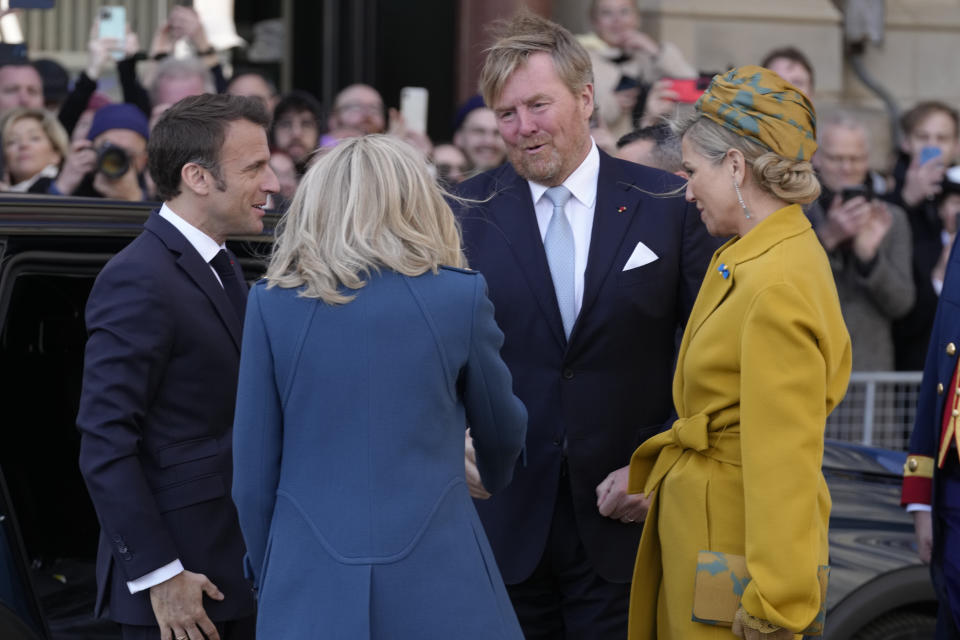 French President Emmanuel Macron, left, and his wife Brigitte Macron are welcomed by Dutch King Willem-Alexander and Queen Maxima outside the royal palace on Dam square in Amsterdam, Netherlands, Tuesday, April 11, 2023. French President Emmanuel Macron begins a two-day state visit to the Netherlands on Tuesday and is making a speech on his vision for the future of Europe. (AP Photo/Peter Dejong)