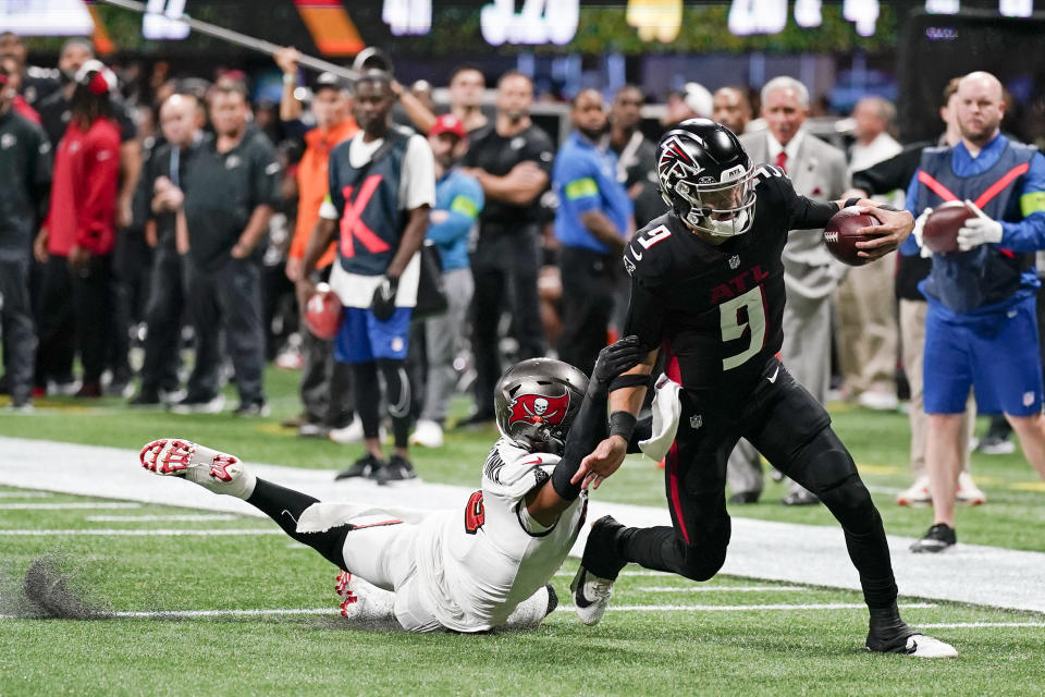 APTOPIX Atlanta Falcons quarterback Desmond Ridder (9) beats Tampa Bay Buccaneers linebacker SirVocea Dennis (8) as he runs in for a touchdown during the second half of an NFL football game, Sunday, Dec. 10, 2023, in Atlanta. (AP Photo/Mike Stewart)