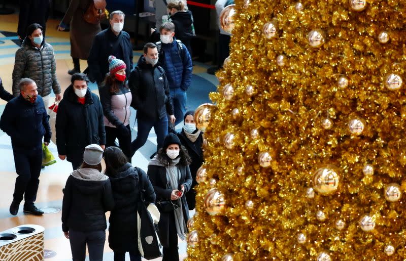 People wear protective face masks as they walk beside Christmas decoration amid the coronavirus disease (COVID-19) outbreak in Berlin