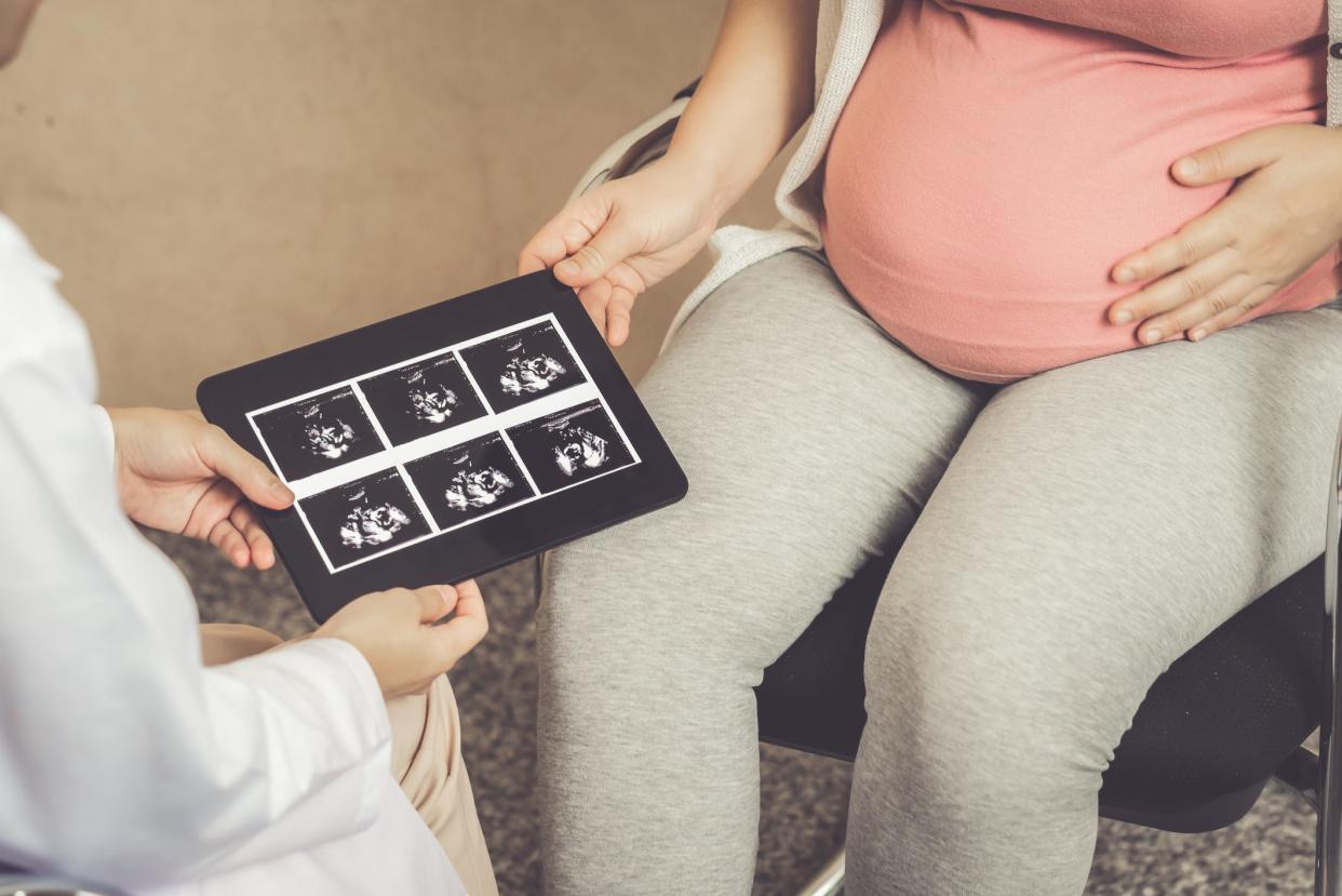 A pregnant woman visiting a gynecologist for a pregnancy consultation.