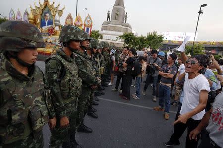 Protesters against military rule face soldiers at the Victory monument in Bangkok May 26, 2014. REUTERS/Damir Sagolj