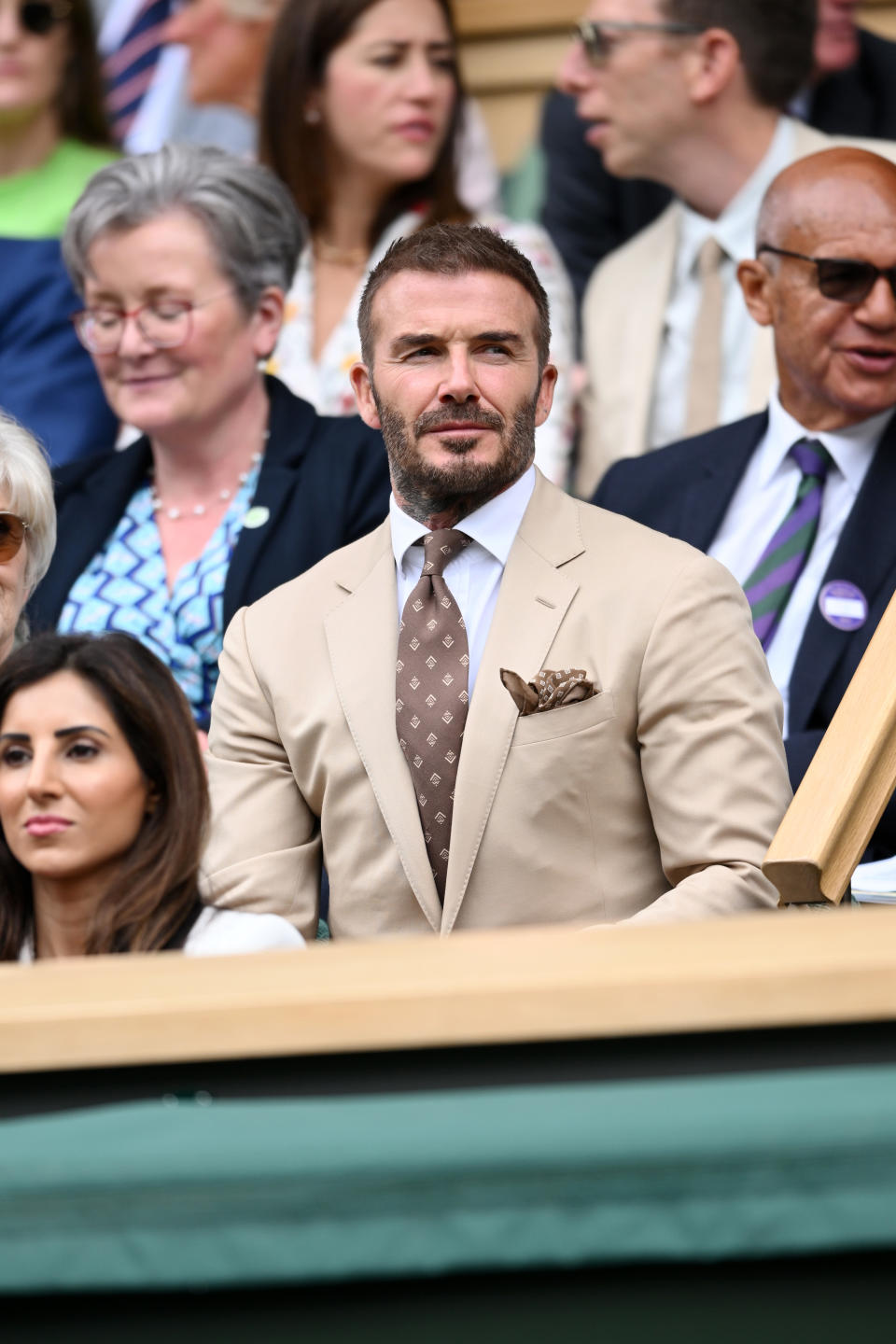 David Beckham wears a beige suit with a brown tie for day three of Wimbledon. (Getty Images)