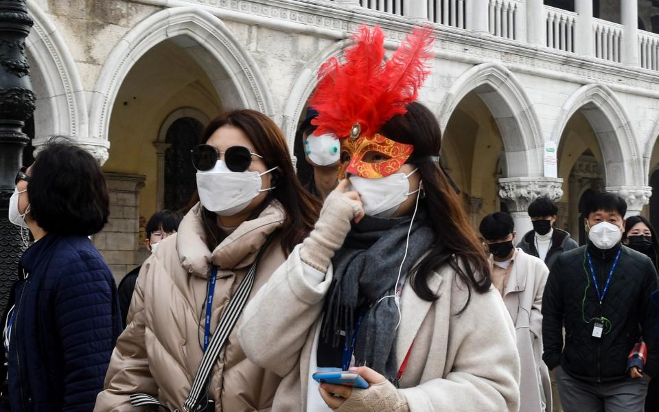 Tourists in Venice sport the city's traditional masks – as well as more modern face coverings - Getty