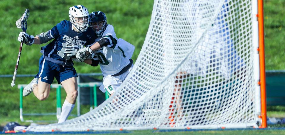 Cohasset's Liam Appleton charges the net during a game against Duxbury on Thursday, April 28, 2022.