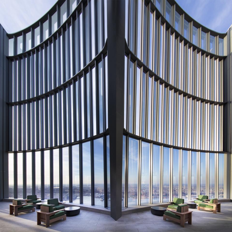 The terrace is protected by a 60-foot-tall glass curtain wall, which comes together at a deep inflection point.