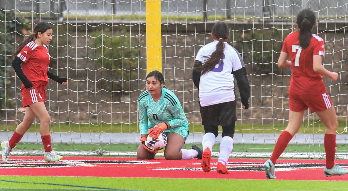 McLane goal keeper Maribel Cabrales, center, blocks a shot from Desert’s Lillian Horne during their Central Section playoff game at McLane Stadium on Monday, Feb. 27, 2023.