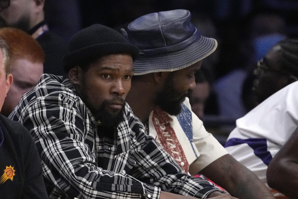 Phoenix Suns' Kevin Durant, left, sits on the bench with Deandre Ayton during the first half of an NBA basketball game against the Los Angeles Lakers Friday, April 7, 2023, in Los Angeles. (AP Photo/Mark J. Terrill)