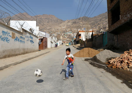 Murtaza Ahmadi, 7, an Afghan Lionel Messi fan, plays football outside his house in Kabul, Afghanistan December 8, 2018. REUTERS/Mohammad Ismail