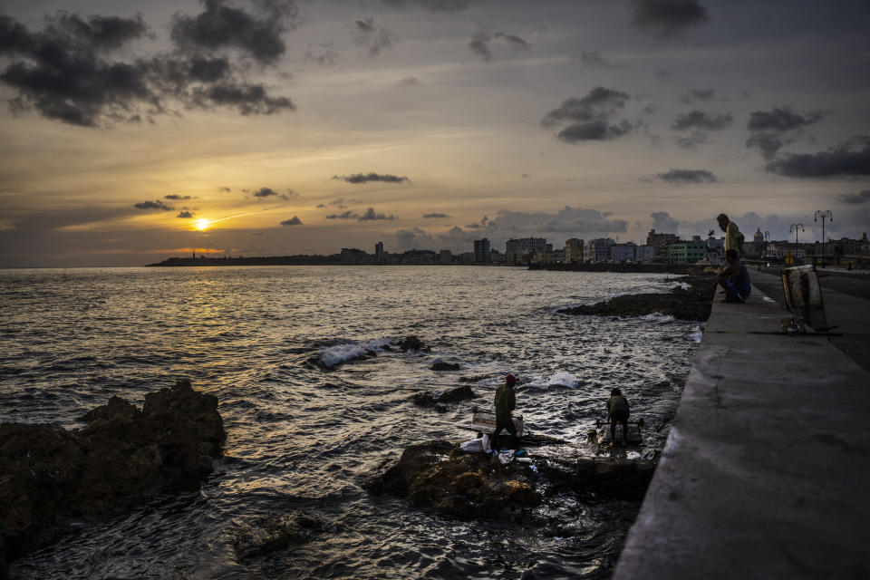 Fishermen with boats made of cork finish working at dawn along the Malecon sea wall in Havana, Cuba, Wednesday, June 22, 2022. Many of the island's people live along a coast prone to storms, hurricanes and the ravages of salty air and water, triggering building collapses in the capital and damaging homes that are already in poor condition. (AP Photo/Ramon Espinosa)