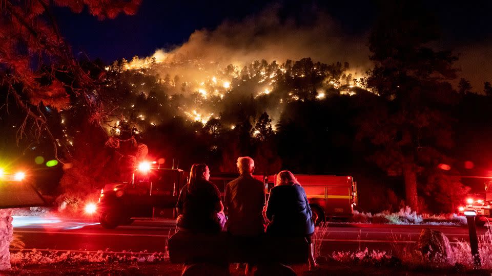 Residents watch part of the Sheep Fire burn through a forest on a hillside near their homes in Wrightwood, California, on June 11, 2022.  - Kyle Grillot/Reuters