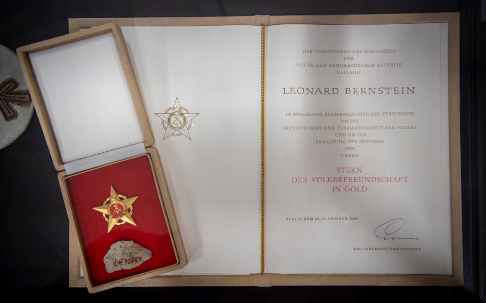 A piece of the Berlin Wall with "Lenny" written on it along with a certificate and medal to recognize Bernstein's performance near the wall are part of the Bernstein Collection at the Jacobs School of Music at Indiana University.