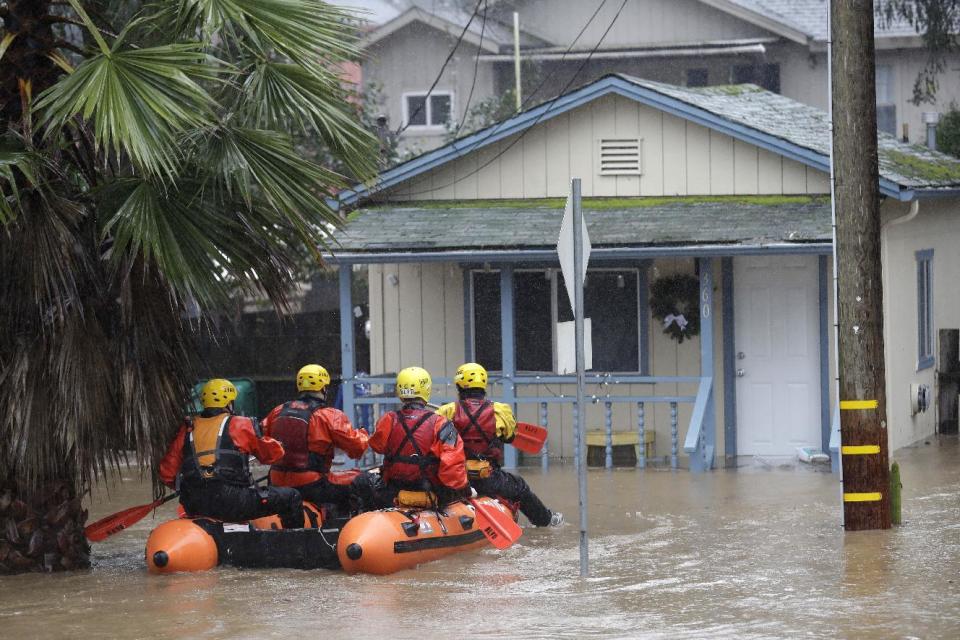 Rescue crews survey a flooded neighborhood Tuesday, Feb. 7, 2017, in Felton, Calif. Flash flood watches are in place for parts of Northern California down through the Central Coast as heavy rains swamp roads and threaten to overtop rivers and creeks. (AP Photo/Marcio Jose Sanchez)