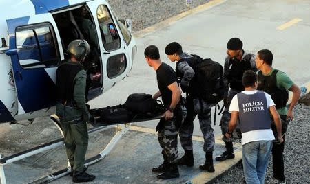 Military police soldiers carry their belongings as they board a helicopter, during a military police strike over wages, at Special Mission Battalion (BME) in Vitoria, Espirito Santo, Brazil, February 12, 2017. REUTERS/Paulo Whitaker