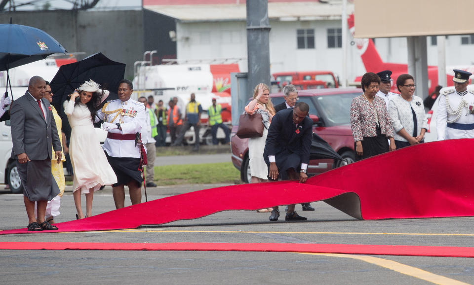 Local officials try to smooth out the red carpet amid the windy weather. Photo: Getty