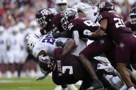 Abilene Christian running back Jordon Vaughn (26) is tackled for a loss by a swarm of Texas A&M defenders led by Texas A&M defensive lineman McKinnley Jackson, top center, of an NCAA college football game Saturday, Nov. 18, 2023, in College Station, Texas. (AP Photo/Sam Craft)