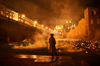 <p>A visitor is seen amongst lit torches, part of the installation ‘Beyond the Deepening Shadow’ at the Tower of London, in London, Britain, November 7, 2018. (Photo from Reuters/Dylan Martinez) </p>