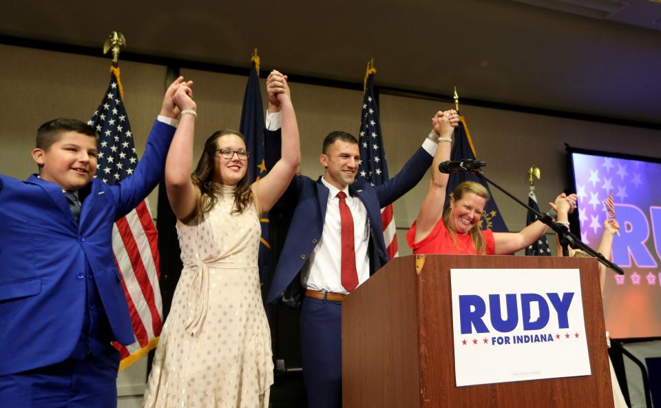 Republican Rudy Yakym raises his arms with his family in victory after he speaks Tuesday, Nov. 8, 2022, at the Gillespie Conference Center in South Bend after defeating Democrat Paul Steury in the race for U.S. Representative in Indiana’s 2nd District. 