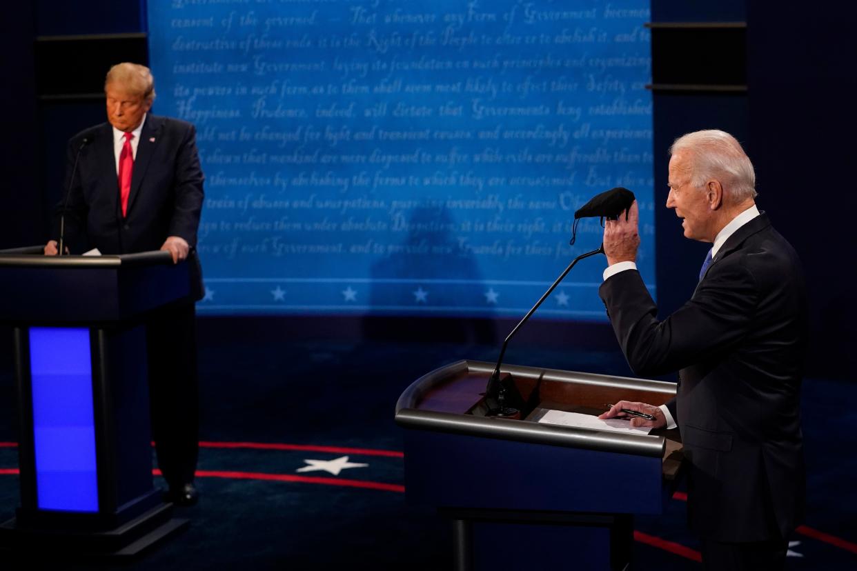 Democratic presidential candidate former Vice President Joe Biden holds up a mask as President Donald Trump takes notes during the second and final presidential debate Thursday, Oct. 22, 2020, at Belmont University in Nashville, Tenn. (AP Photo/Morry Gash, Pool) (AP)