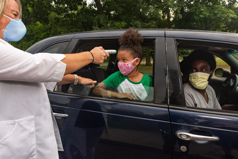 Nurse Sarah Ladd takes 5-year-old Nova Wright's temperature as she’s dropped off at school | Gillian Laub for TIME