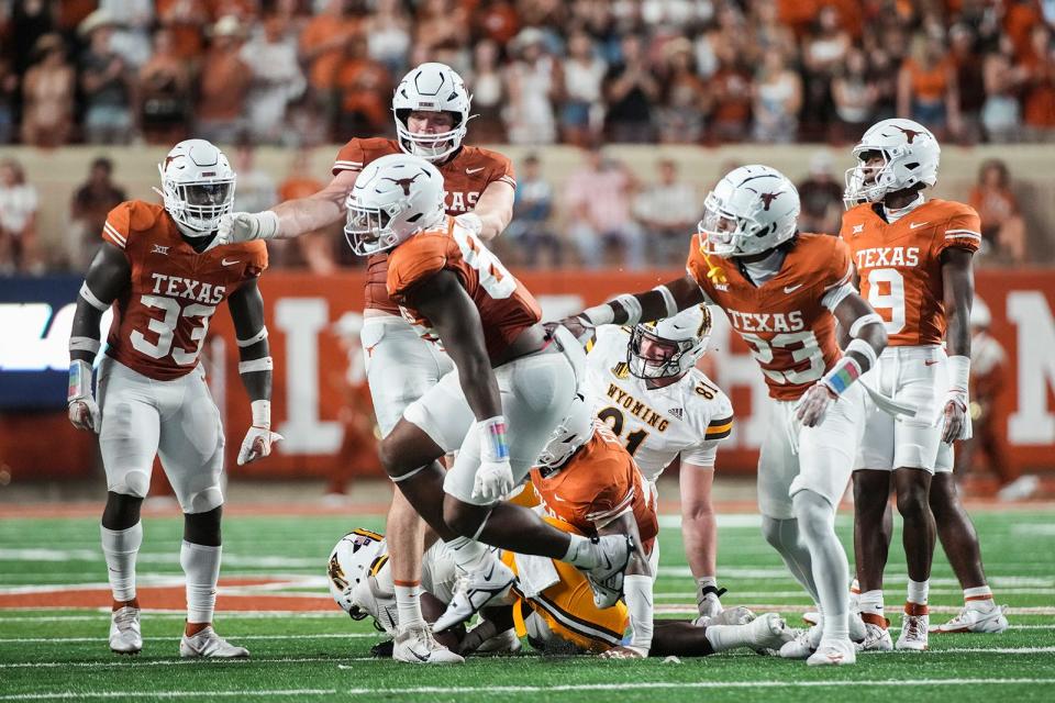 Teammates congratulate Texas end Barryn Sorrell after he registered a sack in Saturday's 31-10 win over Wyoming. The Horns have eight sacks through three games and are on pace to finish with 34 if they make a bowl game.