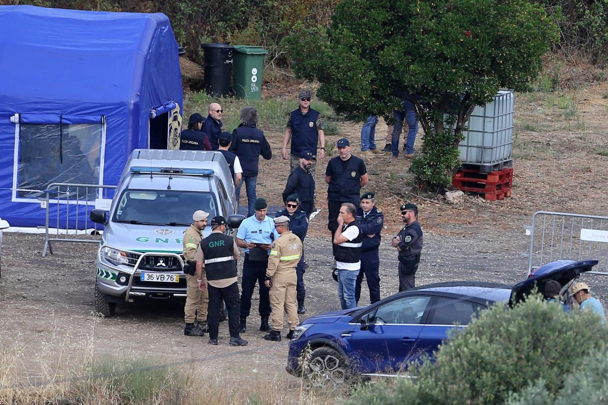 Police officers talk by an operation tent near Barragem do Arade, Portugal (AP)