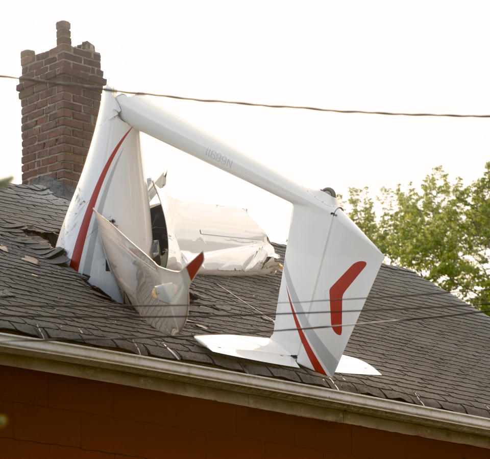 In this Tuesday evening, June 4, 2019 photo, a glider, flown by a local business owner, crashed into a house on Golden Hill Avenue while making its approach to Danbury Airport, in Danbury, Conn. Officials say the pilot sustained minor injuries. (H John Voorhees III/Hearst Connecticut Media via AP)