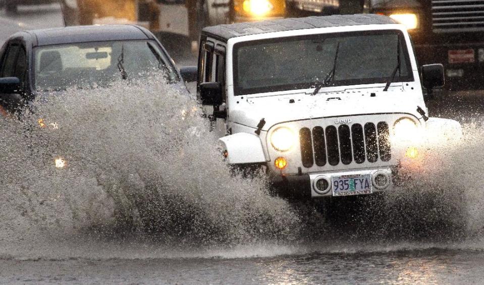 Traffic plows through high water as it merges onto Interstate 5 in Portland, Ore., Monday, Nov. 19, 2012. A powerful storm is pounding the Oregon coast, shutting down marine traffic in and out of several coastal rivers and closing part of highway U.S. 101. (AP Photo/Don Ryan)